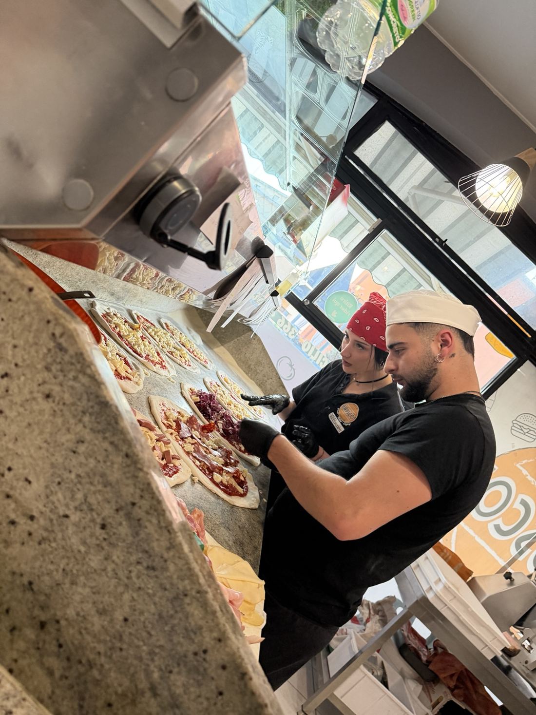 Il team Bruscò prepara le pizze al banco